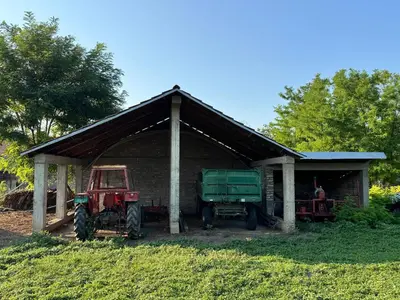 two tractors are parked in a barn at Kuća za odmor ,, Bundevica,,
