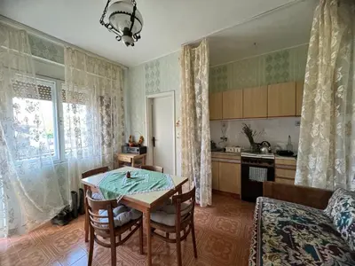 a kitchen with a table and a dining room at Kuća za odmor ,, Bundevica,,