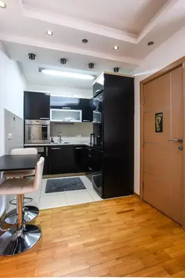 a kitchen with black cabinets and a table and chairs at Apartment Angelo in Belgrade