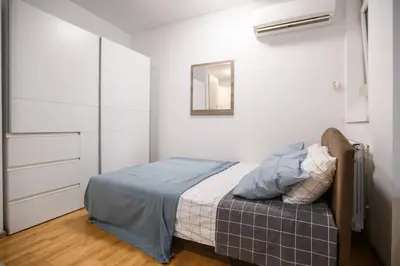 a bedroom with a bed and a mirror on the wall at Apartment Angelo in Belgrade