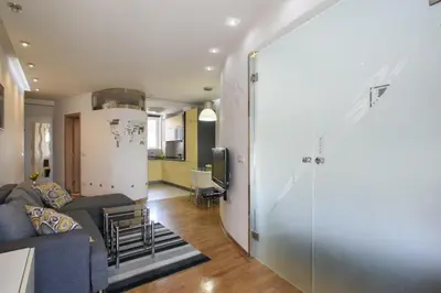a living room with a couch and a kitchen at Apartment Angelo in Belgrade