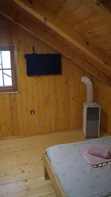 a bedroom with a bed in a wooden room at La dolce vita in Inđija