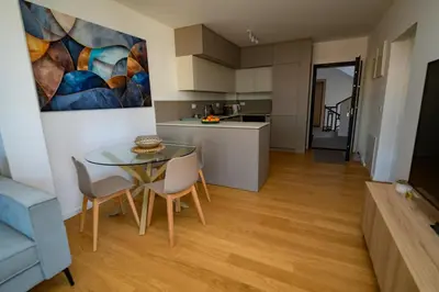 a kitchen and a dining room with a table and chairs at GueZt Dobanovačka 93A in Belgrade
