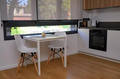 a kitchen with a white table and two chairs at GueZt Dobanovačka 93A in Belgrade