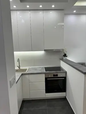 a white kitchen with white cabinets and a sink at Apartman Mojsilović in Ub