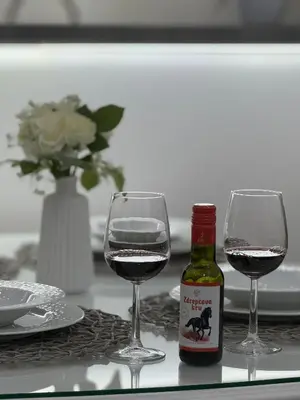 two wine glasses and a bottle of wine on a table at Apartman Mojsilović in Ub