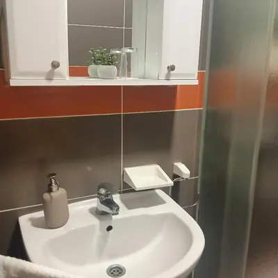 a bathroom with a white sink and a mirror at Vila Eni in Smederevo