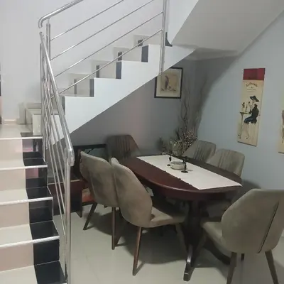 a dining room with a table and chairs and stairs at Vila Eni in Smederevo