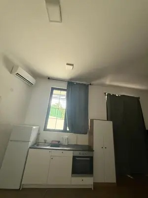 a kitchen with white cabinets and a window at Amar3 in Belgrade