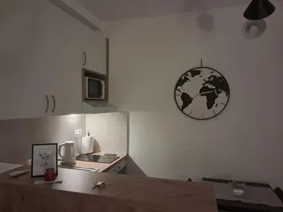 a kitchen with a table and a clock on the wall at TaMiLux apartments in Belgrade