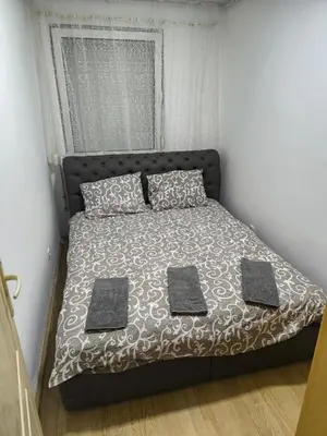 a bed with two pillows on it in a bedroom at R & P Apartman 2 Mladenovac in Mladenovac