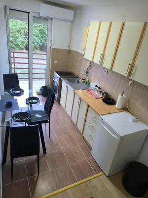 a small kitchen with a table and a dining room at R & P Apartman 2 Mladenovac in Mladenovac