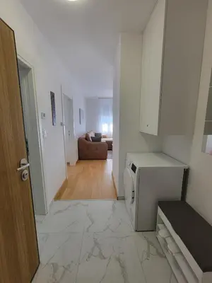 a kitchen with a microwave and a living room at Park residence Apartman 2, Mirijevo, Serbia in Belgrade