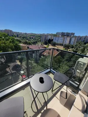 a balcony with a table and chairs on a building at Park residence Apartman 2, Mirijevo, Serbia in Belgrade