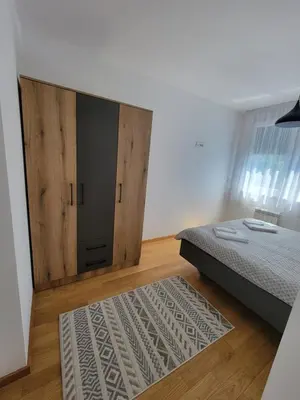 a bedroom with a bed and a large wooden door at Park residence Apartman 2, Mirijevo, Serbia in Belgrade