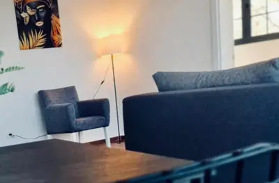 a living room with a couch and a chair and a lamp at Amar 1 in Belgrade