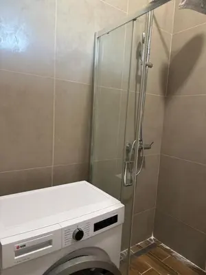 a shower stall with a washing machine in a bathroom at Amar 3 in Belgrade
