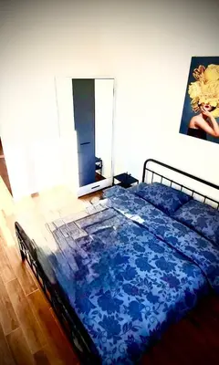 a bedroom with a bed with a blue comforter at Amar 1 in Belgrade