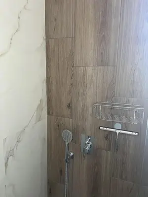 a shower in a bathroom with a stone wall at Lemon Place in Belgrade