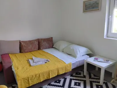 a small bed in a room with a yellow blanket at Sunny Villa in Belgrade