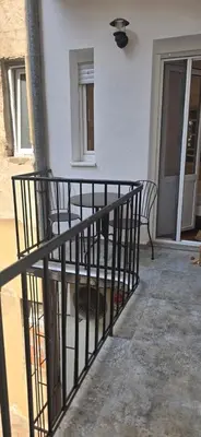 a porch with two chairs and a fence at Admiral Suite in Belgrade