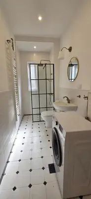 a bathroom with a toilet sink and a washing machine at Admiral Suite in Belgrade