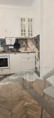 a kitchen with white cabinets and a counter top at Admiral Suite in Belgrade