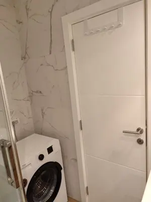 a washing machine in a bathroom next to a shower at New Belgrade Cozy Base in Belgrade