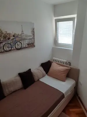 a couch in a room with a bike on the wall at New Belgrade Cozy Base in Belgrade