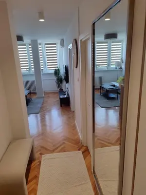 a hallway with a mirror and a living room at New Belgrade Cozy Base in Belgrade