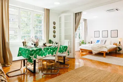a living room with a table and a bed at Chill Flow 110m2 with Balcony Old Town Renovated in Belgrade