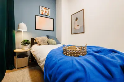 a bedroom with a bed with a blue blanket at Chill Flow 110m2 with Balcony Old Town Renovated in Belgrade
