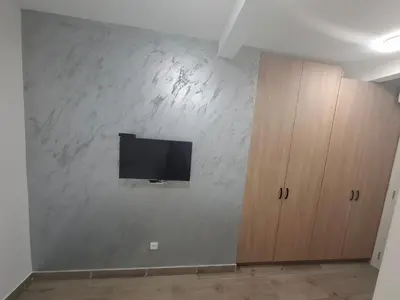 a living room with a tv on a white wall at Burence -m in Železnik