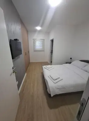 a bedroom with a white bed and a television at Burence -m in Železnik
