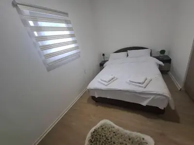 a white bedroom with a bed and a window at Burence -m in Železnik