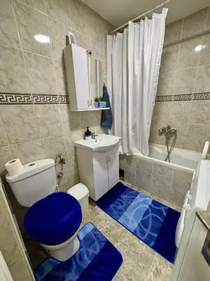 a bathroom with a toilet and a blue floor at Apartman KEJ Smederevo in Smederevo