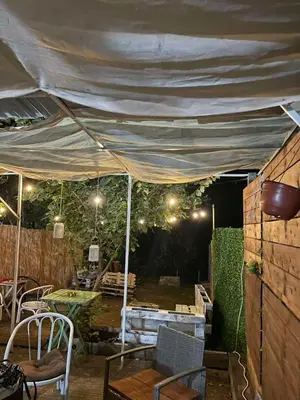 a tent with a table and chairs under it at Zmajevo Gnezdo II Water House in Beograd