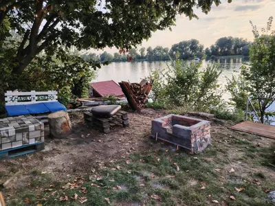 a group of furniture on the ground next to a lake at Zmajevo Gnezdo II Water House in Beograd
