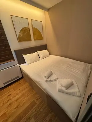 a small bedroom with a bed with two towels on it at Dukk in Belgrade
