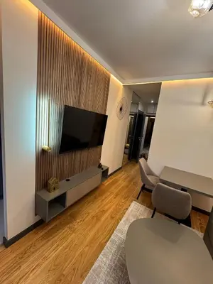 a living room with a television and a table and chairs at Dukk in Belgrade