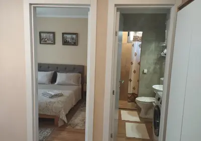 a bedroom with a bed and a bathroom with a toilet at Prenoćište Lana 3 in Novi Banovci