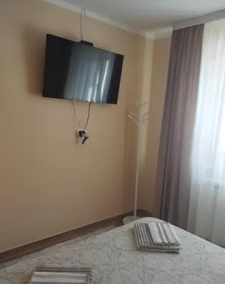 a room with a bed with a television on the wall at Prenoćište Lana 3 in Novi Banovci