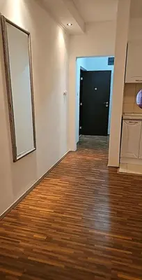 an empty room with a hallway with wood floors and a door at Swiss Luxury Apartment in Beograd