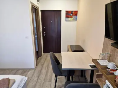 a room with a table and chairs and a door at Apartman New in Belgrade