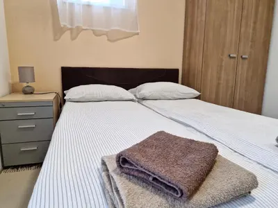 a bed with a blanket and a towel on it at Apartman New in Belgrade