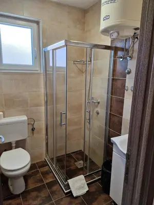 a bathroom with a shower with a toilet and a sink at Apartman New in Belgrade