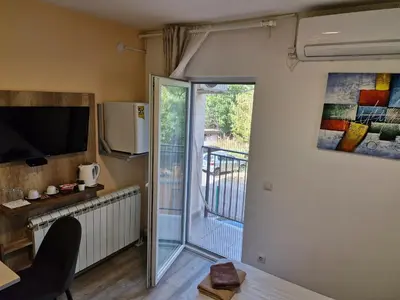 a living room with a television and a balcony at Apartman New in Belgrade