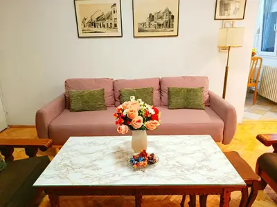 a living room with a couch and a table with flowers at Home Sweet Home No1 in Belgrade