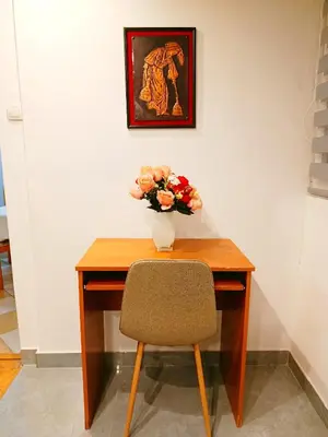 a wooden desk with a vase of flowers on it at Home Sweet Home No1 in Belgrade