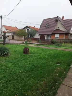 a yard with a house with a fence and green grass at Dve Breze